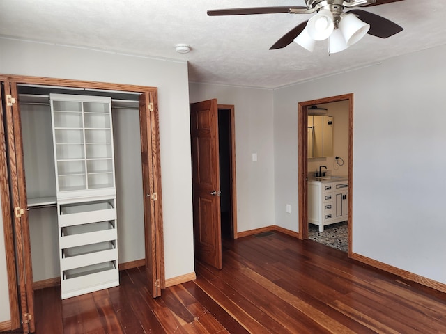 unfurnished bedroom featuring a closet, ceiling fan, a textured ceiling, ensuite bathroom, and dark hardwood / wood-style floors