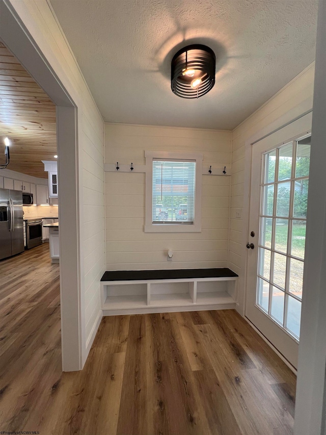 mudroom with a textured ceiling, plenty of natural light, and hardwood / wood-style floors