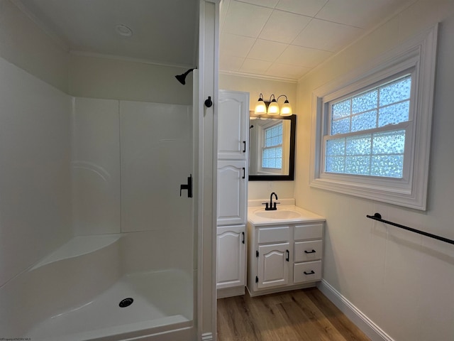 bathroom with ornamental molding, vanity, hardwood / wood-style flooring, and walk in shower