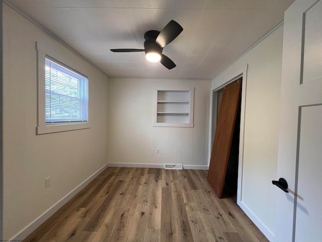 unfurnished bedroom with light wood-type flooring, ceiling fan, and a closet