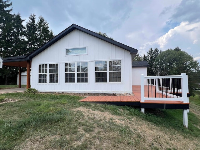 view of side of property with a lawn, a garage, and a deck