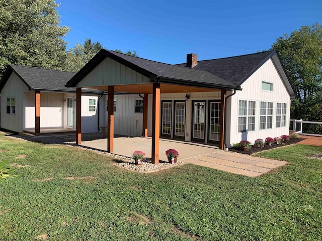 back of property with a lawn and a patio