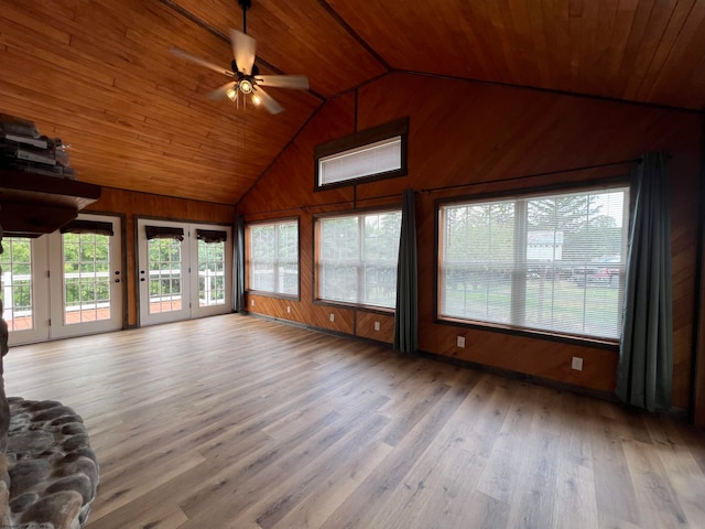 unfurnished living room featuring wood walls, wood-type flooring, ceiling fan, wooden ceiling, and vaulted ceiling