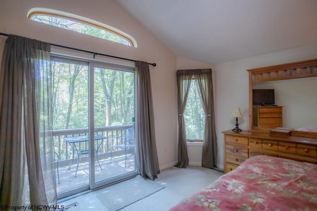 carpeted bedroom featuring multiple windows, lofted ceiling, and access to outside