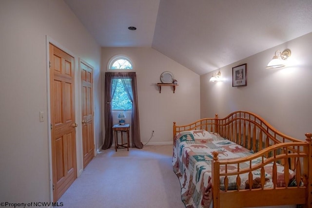 bedroom featuring light colored carpet and vaulted ceiling