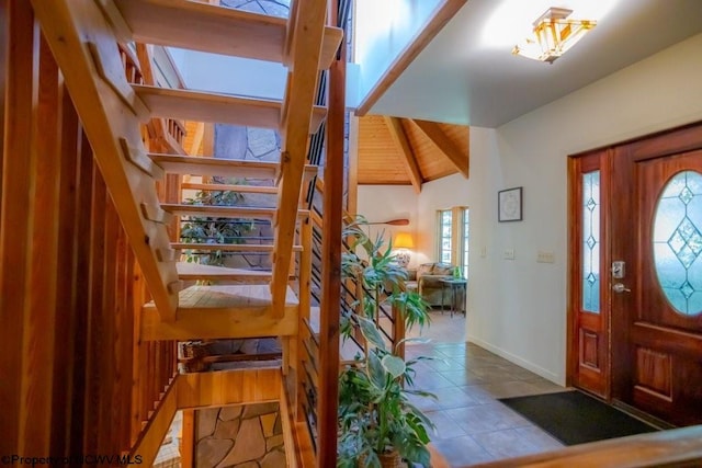 tiled foyer entrance with vaulted ceiling and wooden ceiling