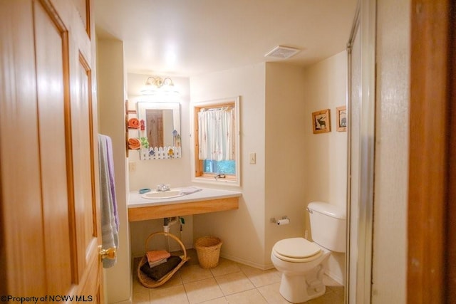 bathroom with tile patterned flooring, toilet, and sink