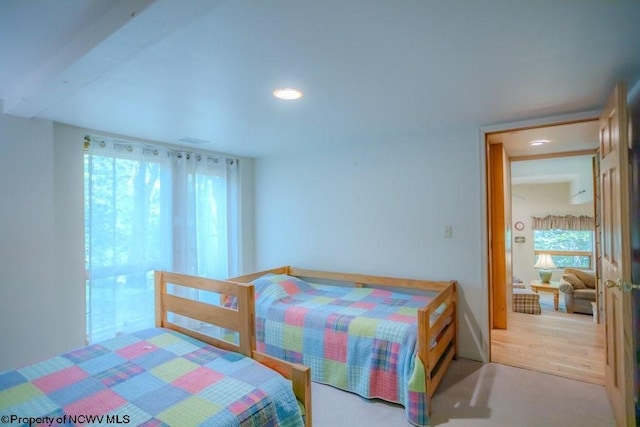 carpeted bedroom with beam ceiling