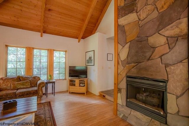 living room with wooden ceiling, light wood-type flooring, a stone fireplace, high vaulted ceiling, and beam ceiling