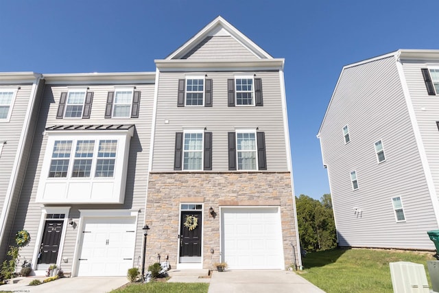 multi unit property featuring a garage and a front lawn