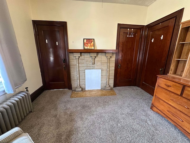 living room with carpet flooring, radiator heating unit, and a brick fireplace