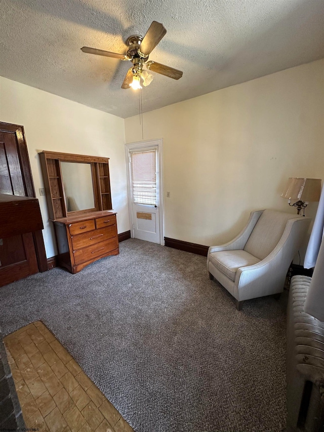 unfurnished room featuring a textured ceiling, ceiling fan, and carpet floors