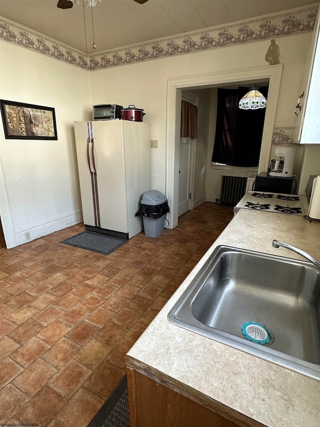 kitchen featuring white appliances, sink, and ceiling fan