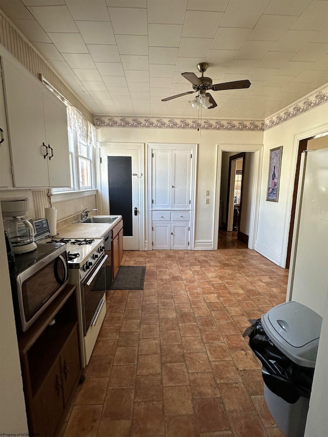 kitchen with white cabinets, sink, stainless steel appliances, and ceiling fan