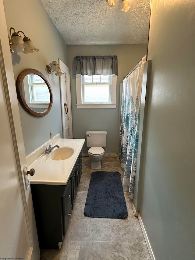 bathroom featuring toilet, a textured ceiling, and vanity