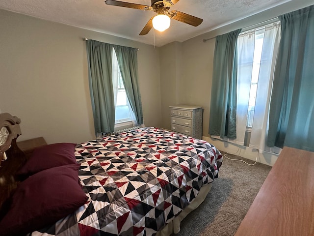 carpeted bedroom with a textured ceiling and ceiling fan