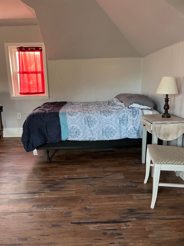 bedroom featuring dark wood-type flooring and vaulted ceiling