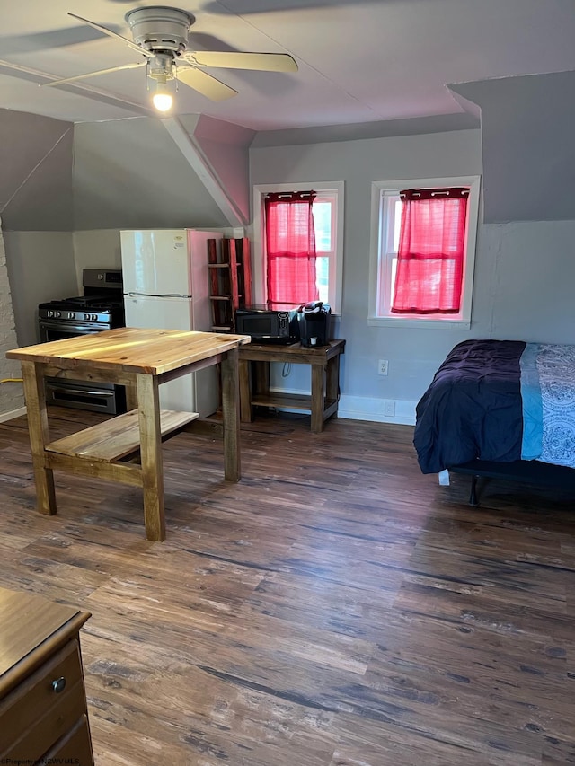 bedroom with white refrigerator, dark hardwood / wood-style flooring, ceiling fan, and lofted ceiling