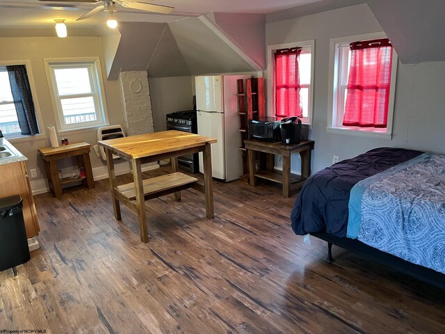 bedroom featuring dark wood-type flooring, heating unit, ceiling fan, and white fridge