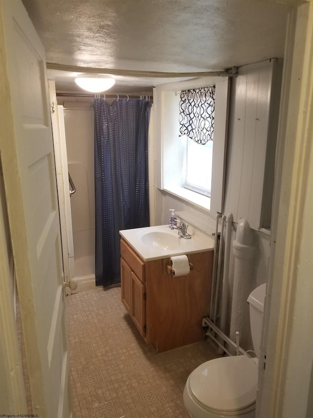 bathroom featuring a shower with shower curtain, toilet, a textured ceiling, and vanity