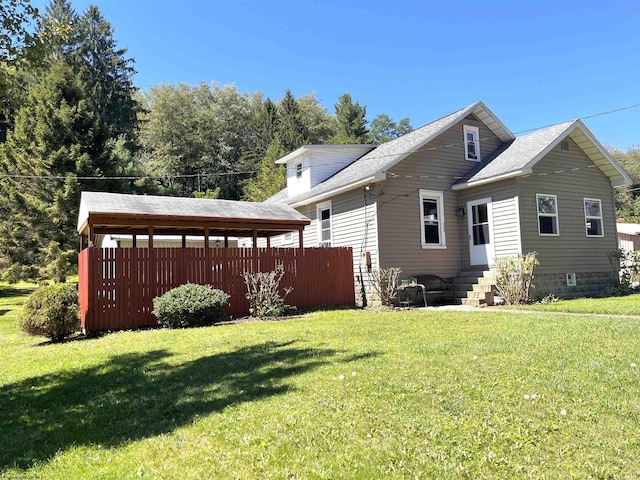 exterior space featuring entry steps, a lawn, and fence