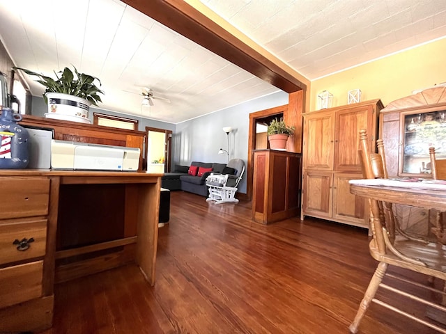 kitchen with dark wood-type flooring, brown cabinetry, and a ceiling fan