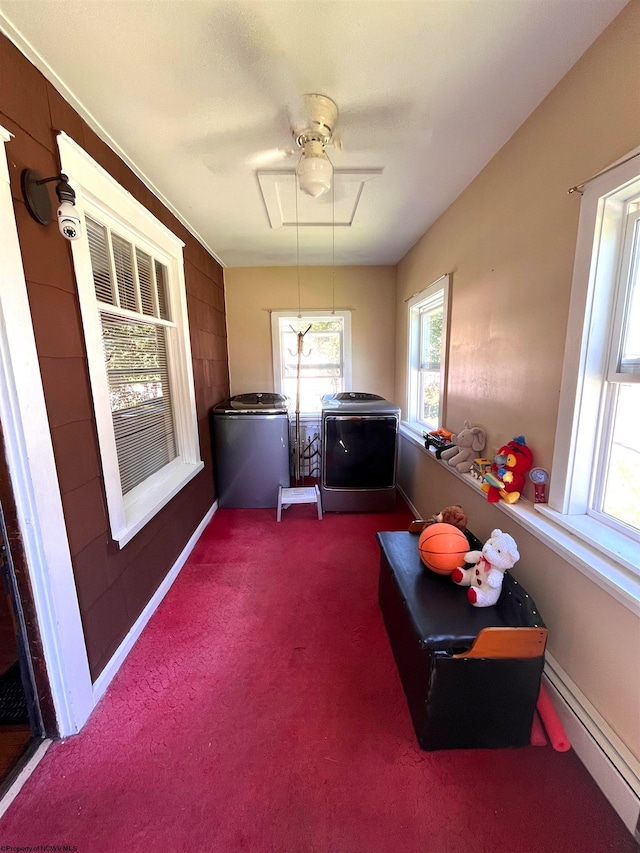 laundry area featuring a baseboard heating unit, carpet floors, washing machine and clothes dryer, and ceiling fan