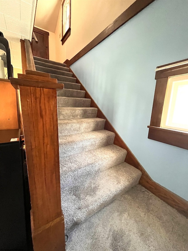 staircase with baseboards and carpet flooring