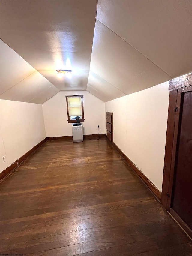 bonus room featuring lofted ceiling, dark wood-style floors, and baseboards