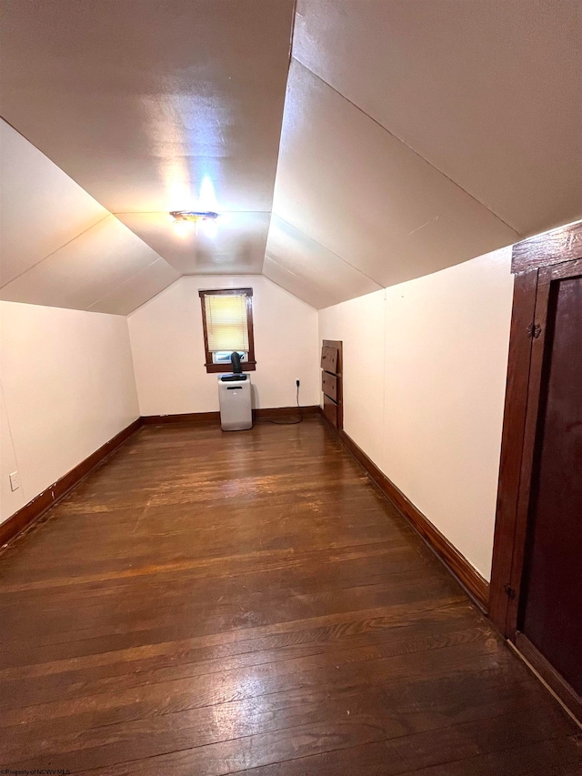 bonus room with lofted ceiling and dark wood-type flooring