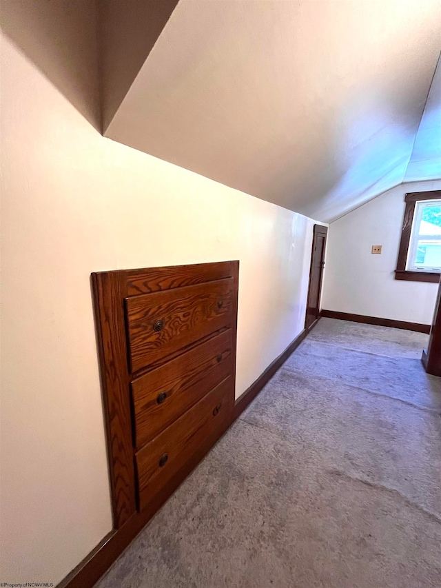 bonus room with lofted ceiling and carpet flooring