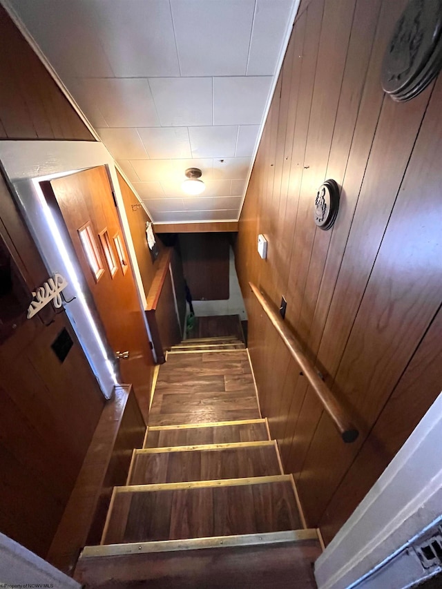 stairway with wood-type flooring and wood walls