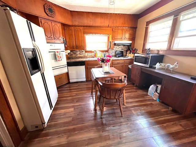 kitchen with dark wood-type flooring, stainless steel appliances, and tasteful backsplash