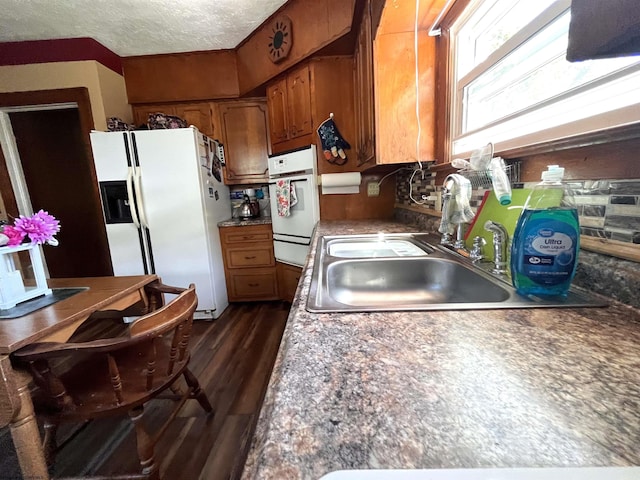 kitchen with dark wood finished floors, a warming drawer, brown cabinetry, a sink, and white fridge with ice dispenser