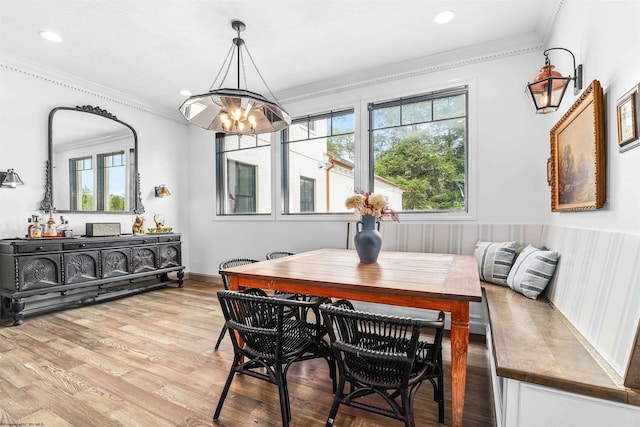 dining room featuring crown molding, light hardwood / wood-style floors, and a notable chandelier