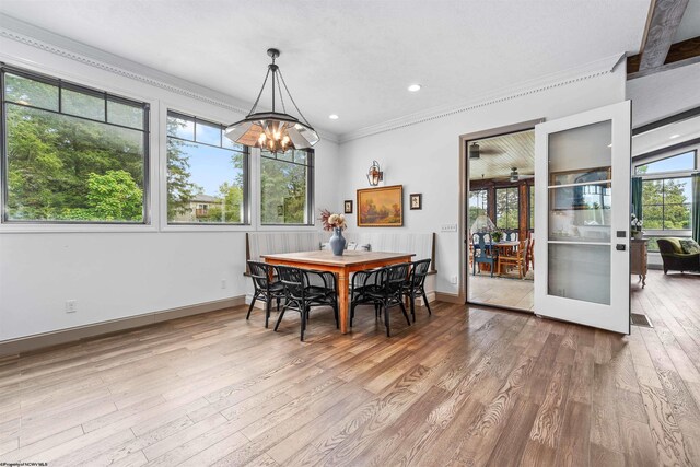 dining room featuring crown molding, hardwood / wood-style floors, an inviting chandelier, and beam ceiling