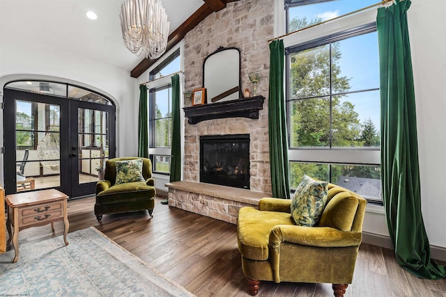 sitting room with a fireplace, a healthy amount of sunlight, hardwood / wood-style floors, and vaulted ceiling with beams