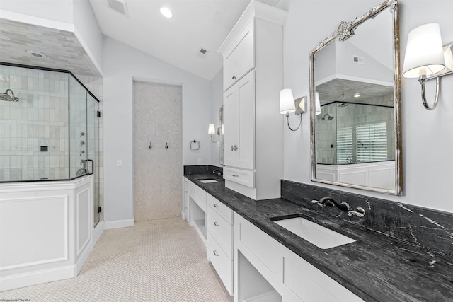 bathroom with tile patterned flooring, a shower with door, vaulted ceiling, and vanity