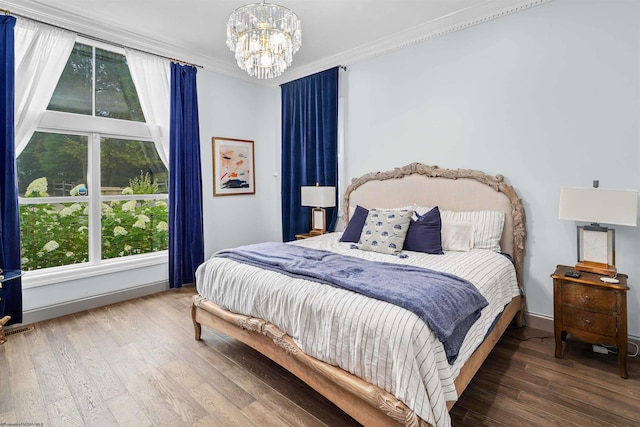 bedroom featuring dark hardwood / wood-style floors, an inviting chandelier, and crown molding