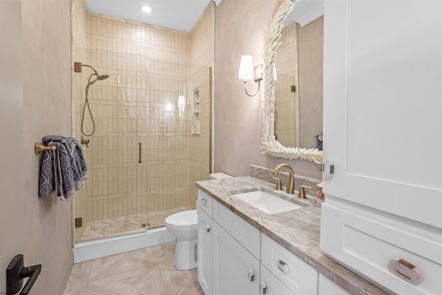 bathroom featuring vanity, a shower with shower door, and toilet