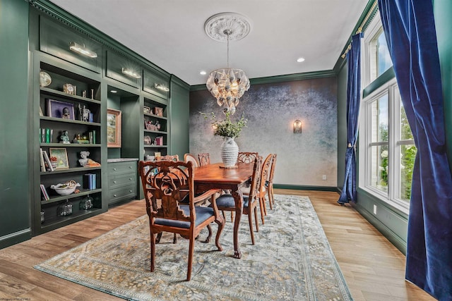 dining area featuring light wood-type flooring, plenty of natural light, a chandelier, and ornamental molding