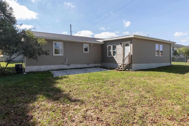 rear view of property featuring a yard and central AC unit