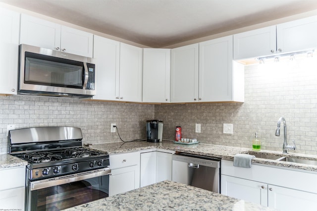 kitchen featuring backsplash, sink, white cabinets, and appliances with stainless steel finishes