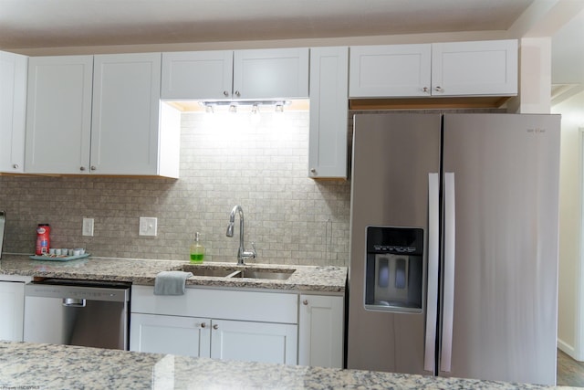 kitchen with white cabinets, appliances with stainless steel finishes, tasteful backsplash, and sink