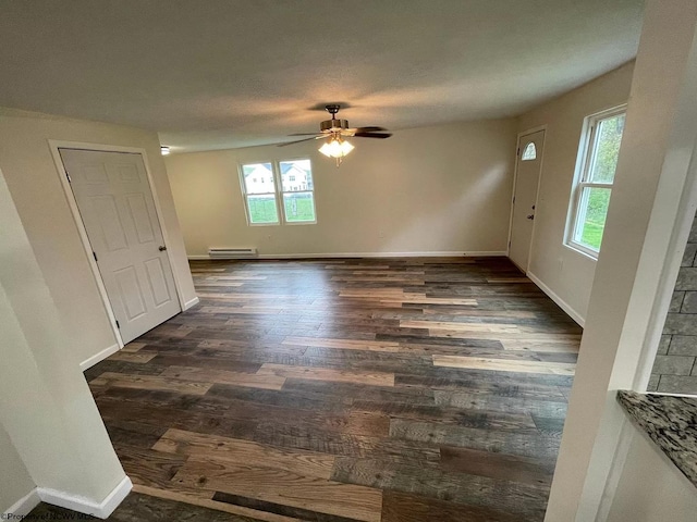 unfurnished room with a wealth of natural light, ceiling fan, a baseboard radiator, and dark hardwood / wood-style floors