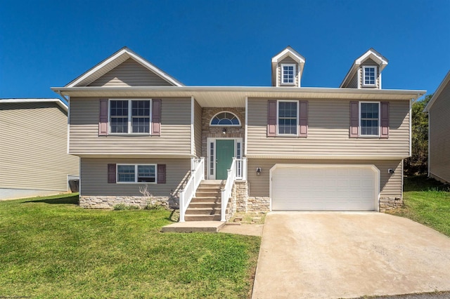 raised ranch with a front yard and a garage