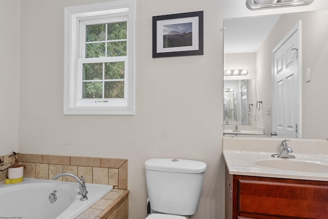 bathroom with vanity, toilet, and tiled tub