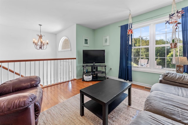 living room featuring a healthy amount of sunlight, hardwood / wood-style floors, and a notable chandelier