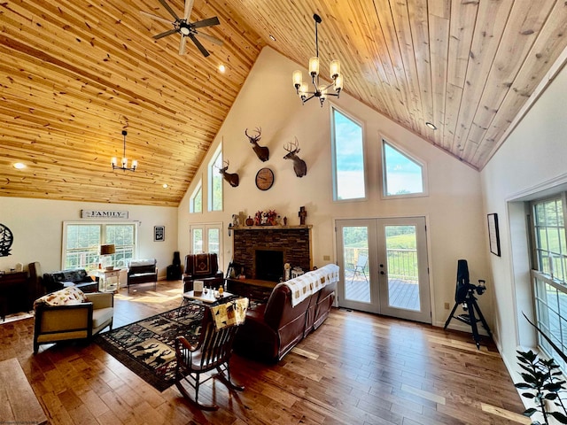 living room with ceiling fan with notable chandelier, high vaulted ceiling, and wooden ceiling