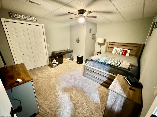 carpeted bedroom featuring a closet, ceiling fan, and a paneled ceiling